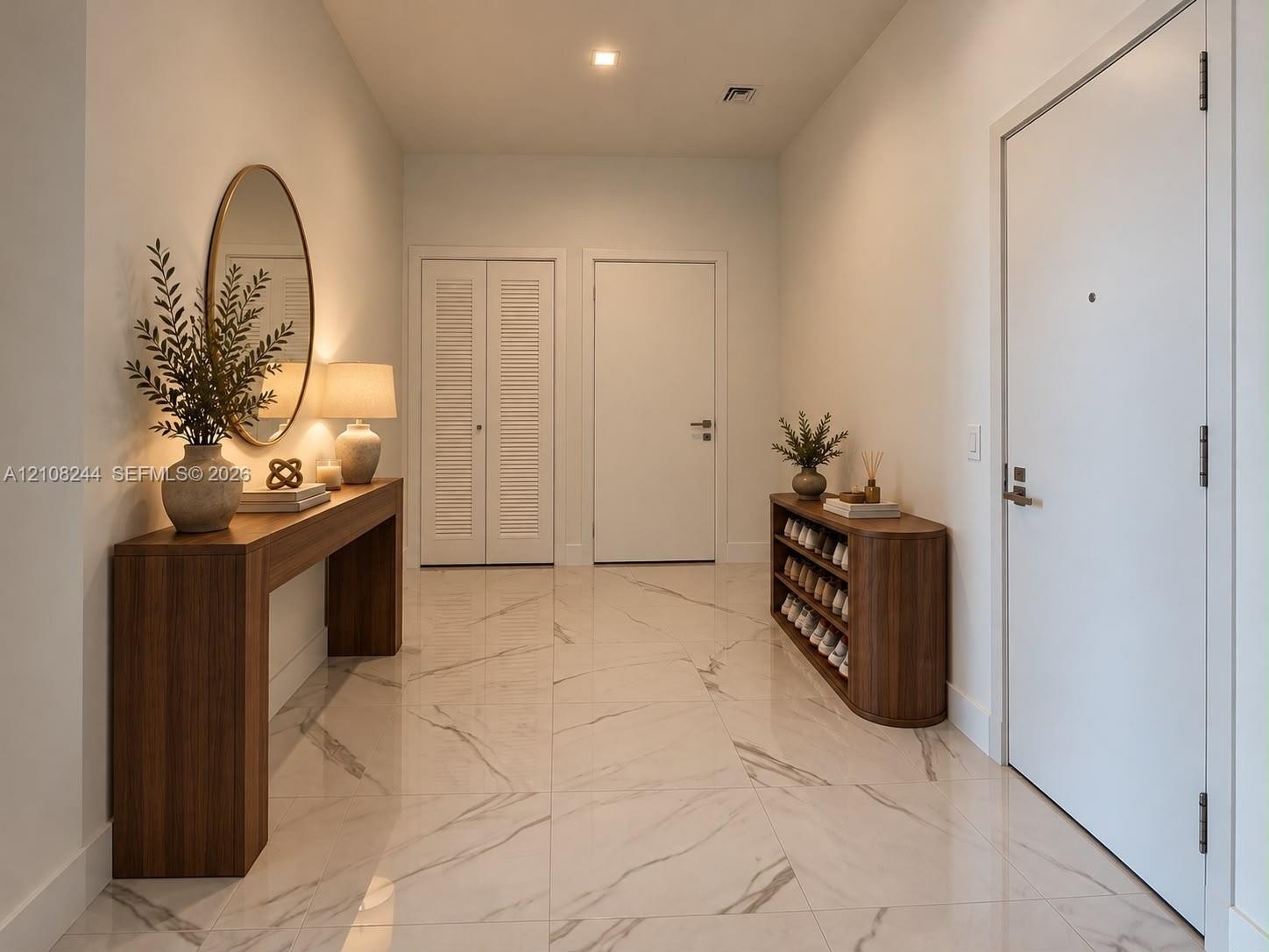 Large-format polished stone flooring with neutral veining, high ceilings with recessed lighting, and crisp white interior doors