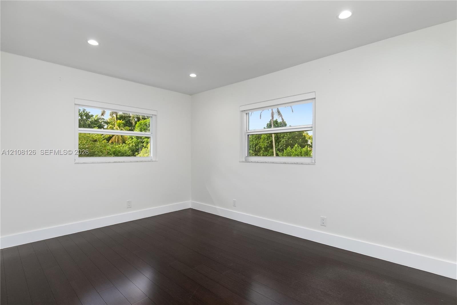 Neutral-toned room with wood-finish flooring, recessed lighting, and double-pane windows