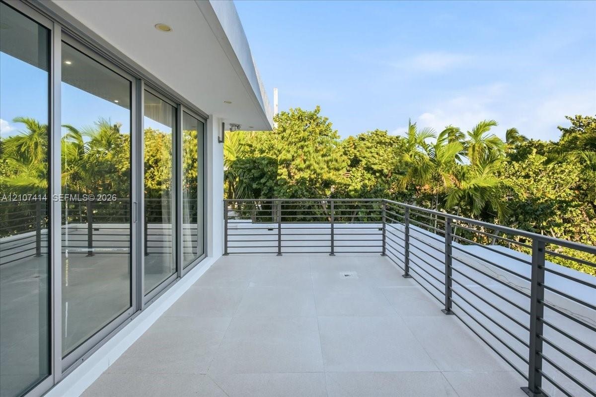 Balcony featuring large-format tile flooring, metal horizontal railing, and expansive floor-to-ceiling glass sliding doors