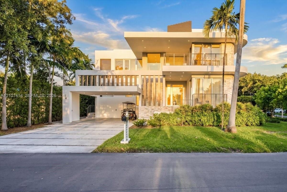Modern multi-level exterior featuring clean geometric lines, stacked stone facade accents, multiple covered balconies with cable railings, and a wide 