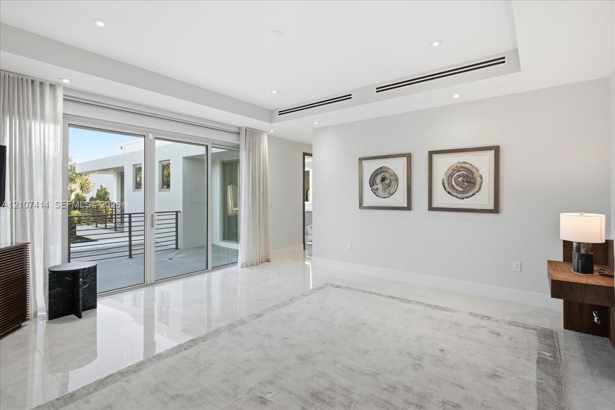 Interior space featuring polished stone flooring, recessed lighting, linear ceiling vents, and large-format sliding glass doors with access to an exte