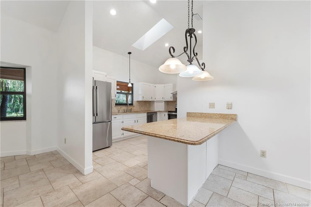 Peninsula for extra counter and cabinet storage.