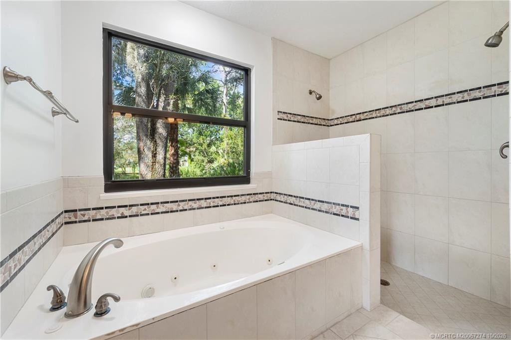 Jetted tub and walk in shower with shower heads on both walls.