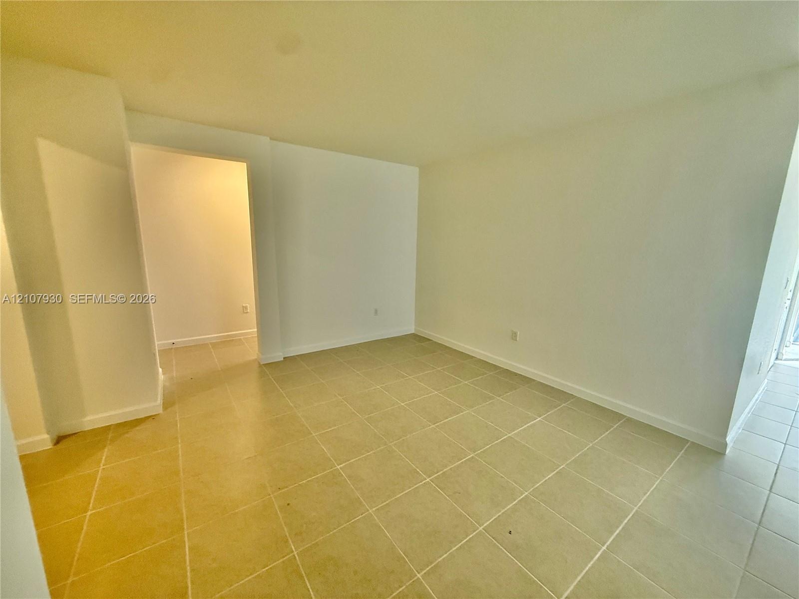 Interior space featuring neutral wall paint and light-colored square tile flooring