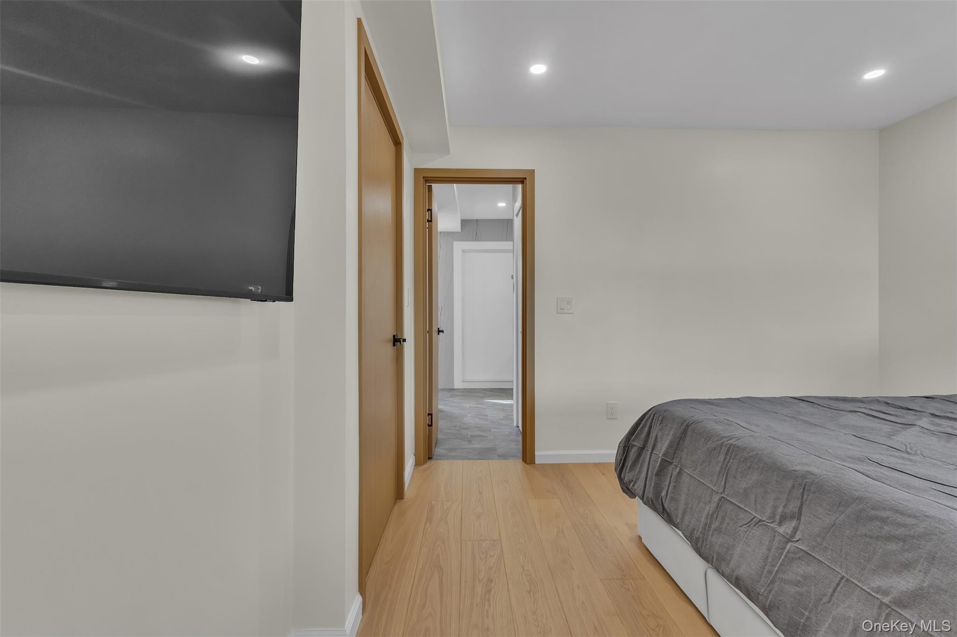 Light-toned wood-finish flooring, recessed ceiling lighting, and solid-core wood-finish doors