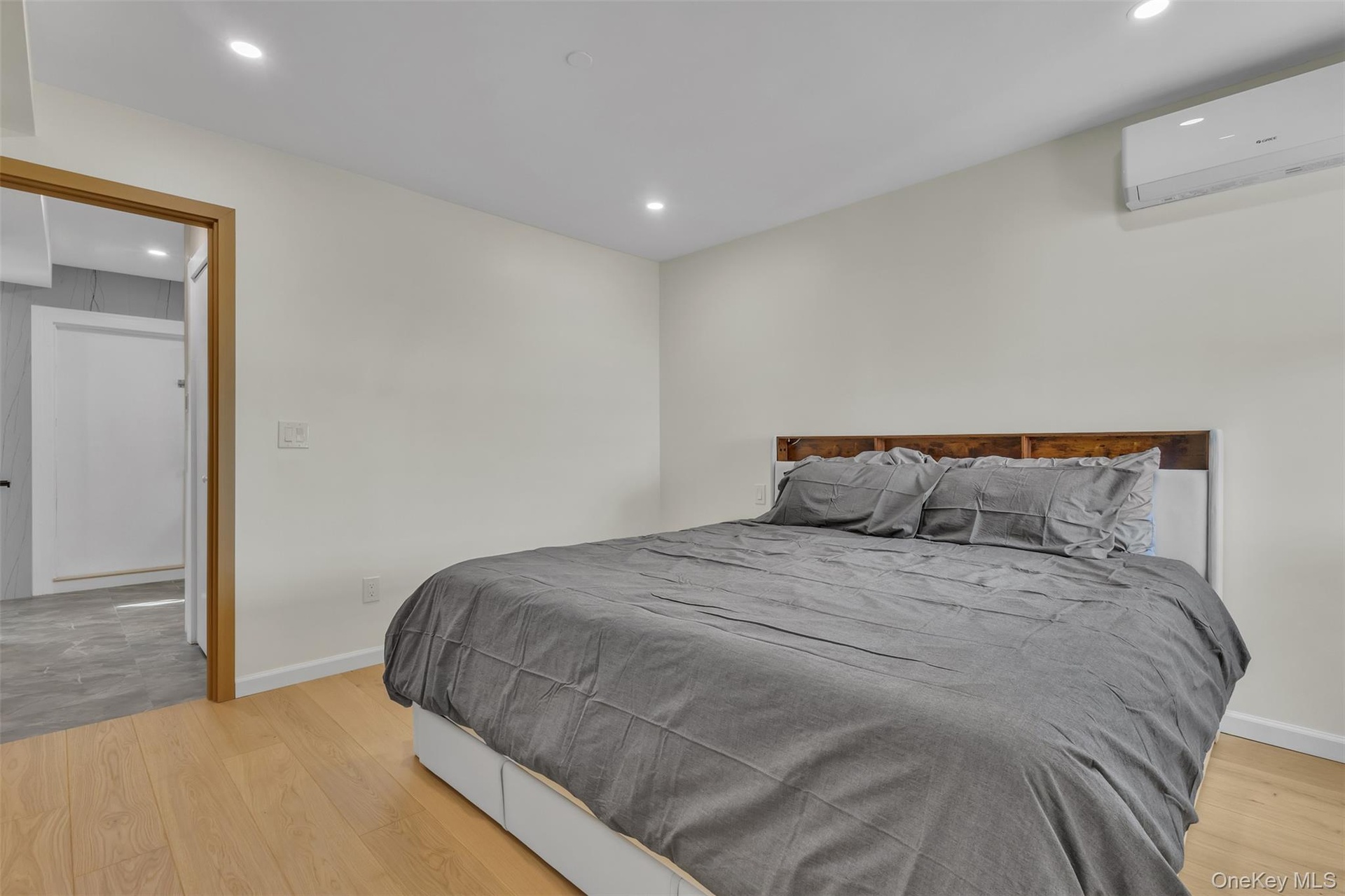 Wood-finish flooring, recessed lighting, and wall-mounted climate control unit
