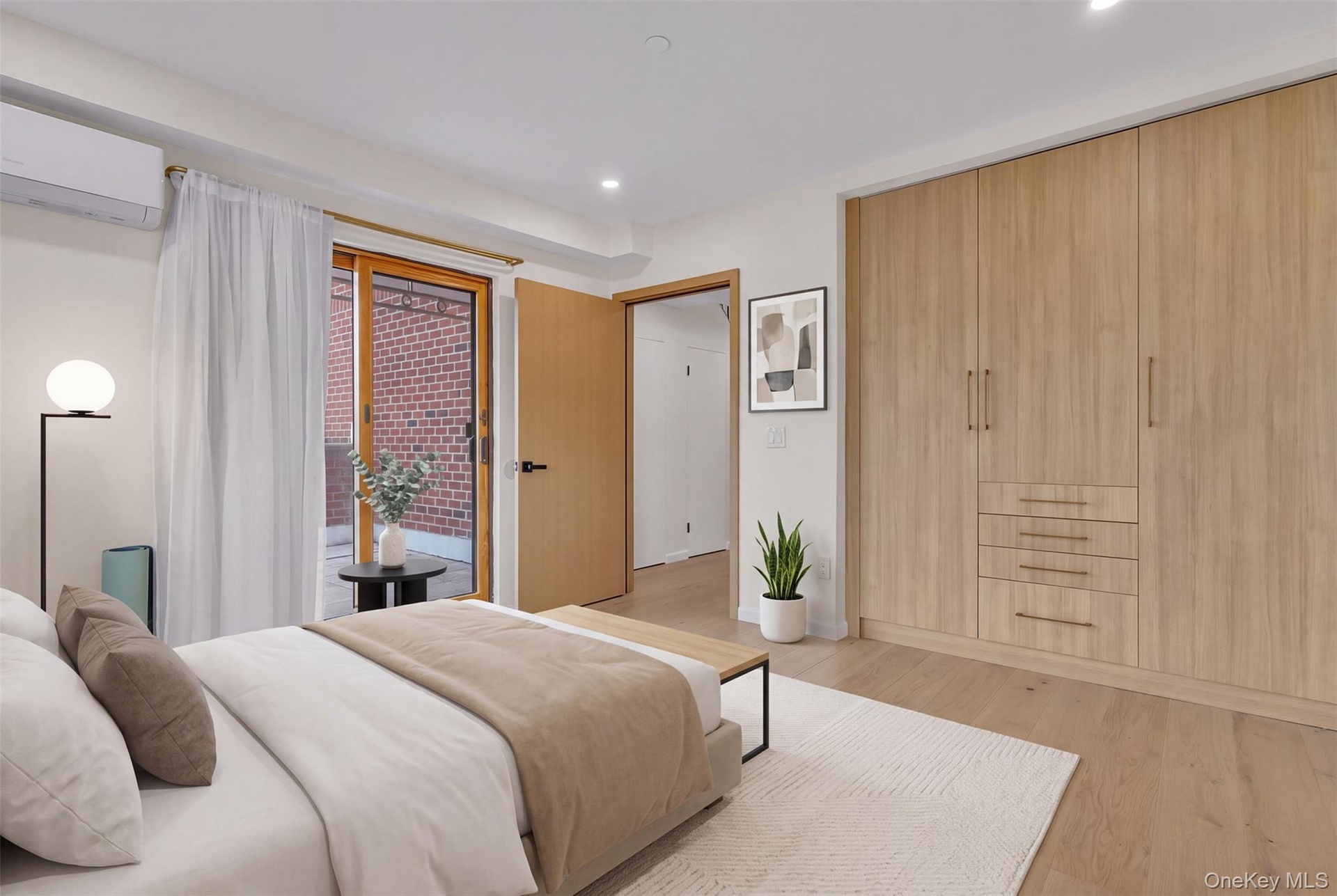 Bedroom featuring floor-to-ceiling custom wood-finish cabinetry with integrated drawers, wood-finish flooring, recessed lighting, and a sliding glass 