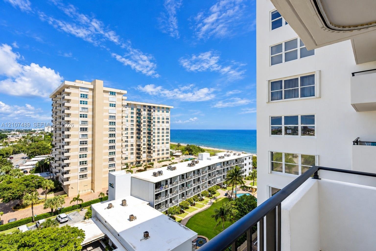Private balcony featuring a black metal railing and expansive coastal scenery