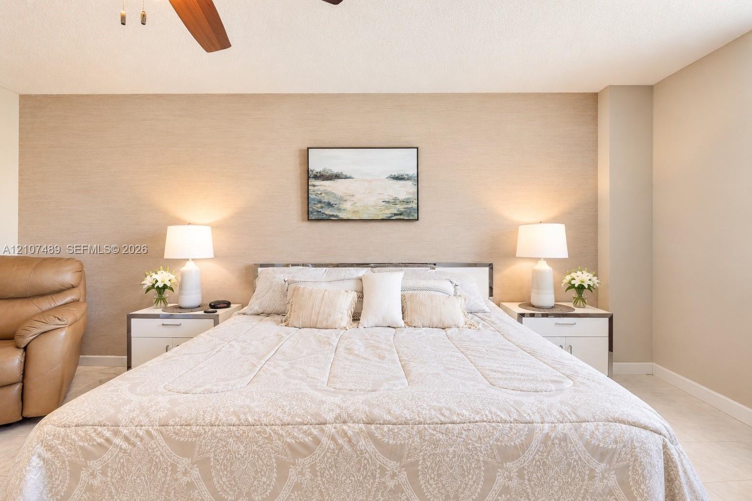 Textured accent wall featuring a neutral finish and ceiling-mounted fan