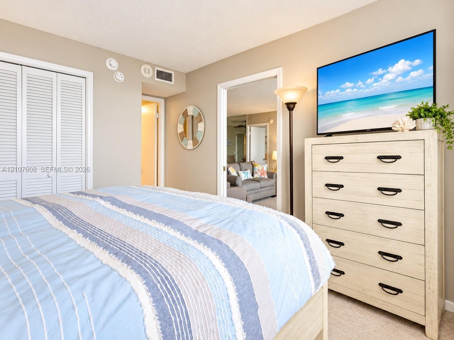 Room interior featuring neutral wall paint, wall-to-wall carpeting, and double-door bi-fold closet