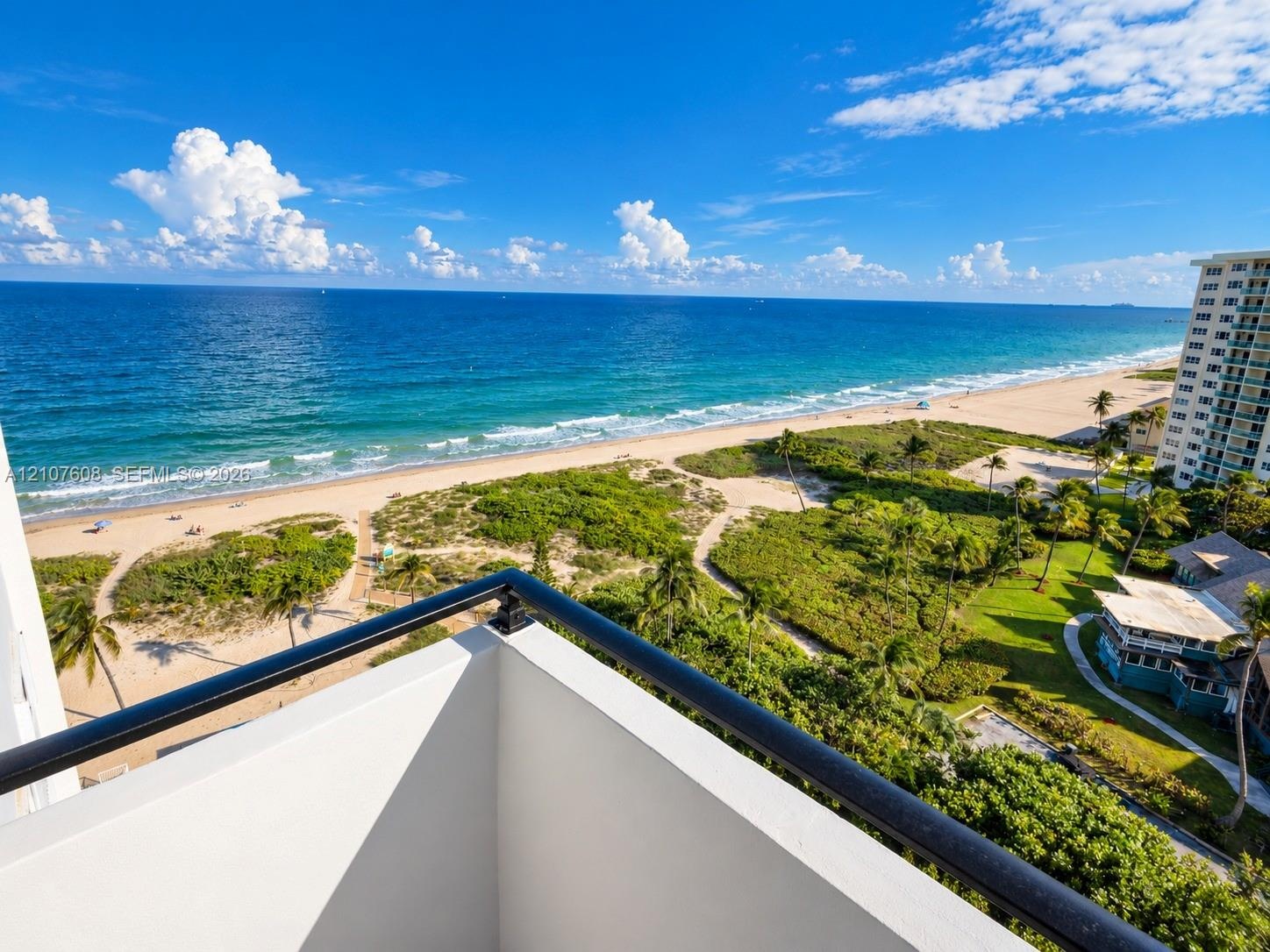 Balcony featuring a black metal railing and expansive coastal scenery