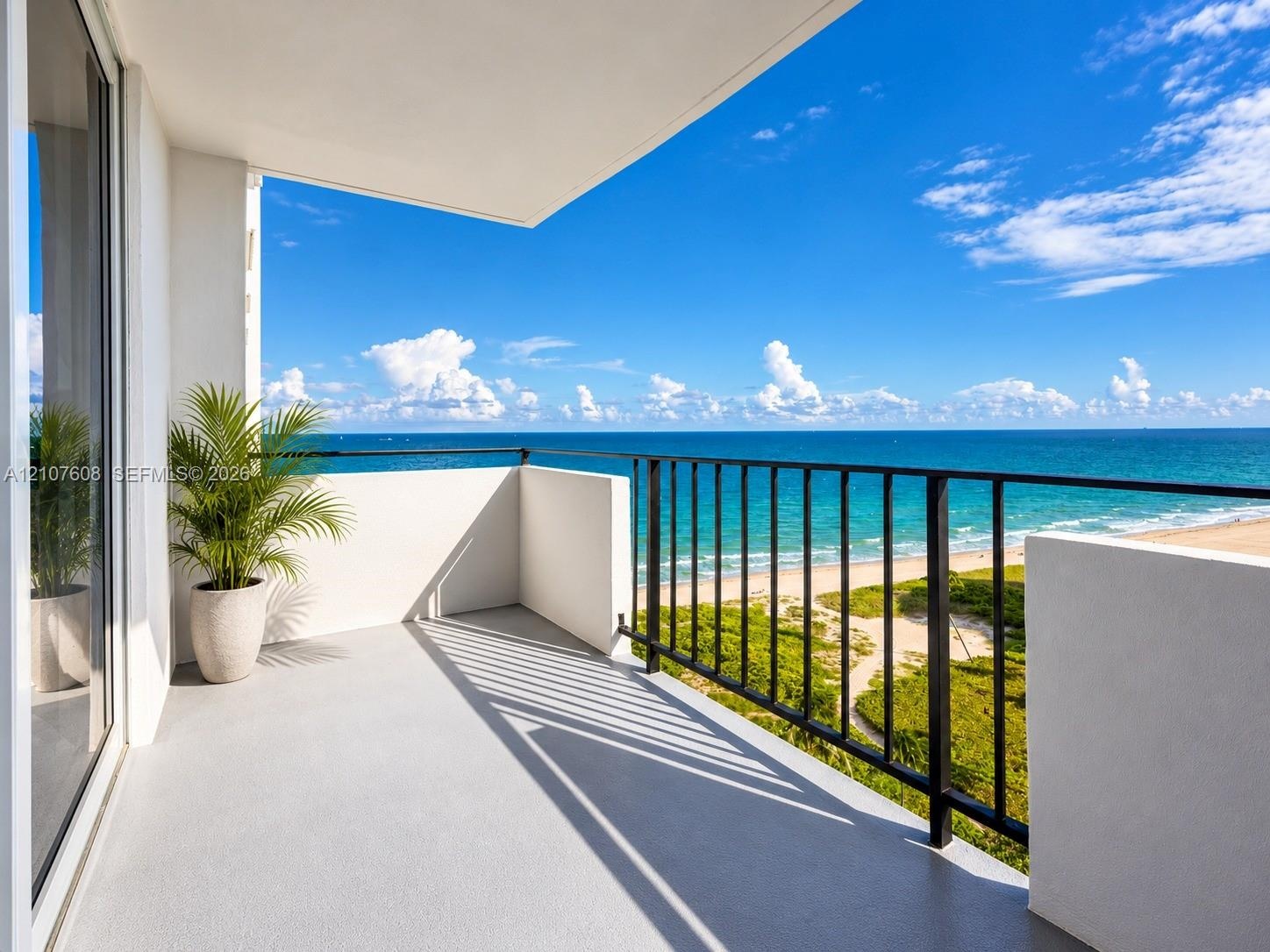 Private balcony featuring a solid surface floor, black metal railing, and direct water frontage