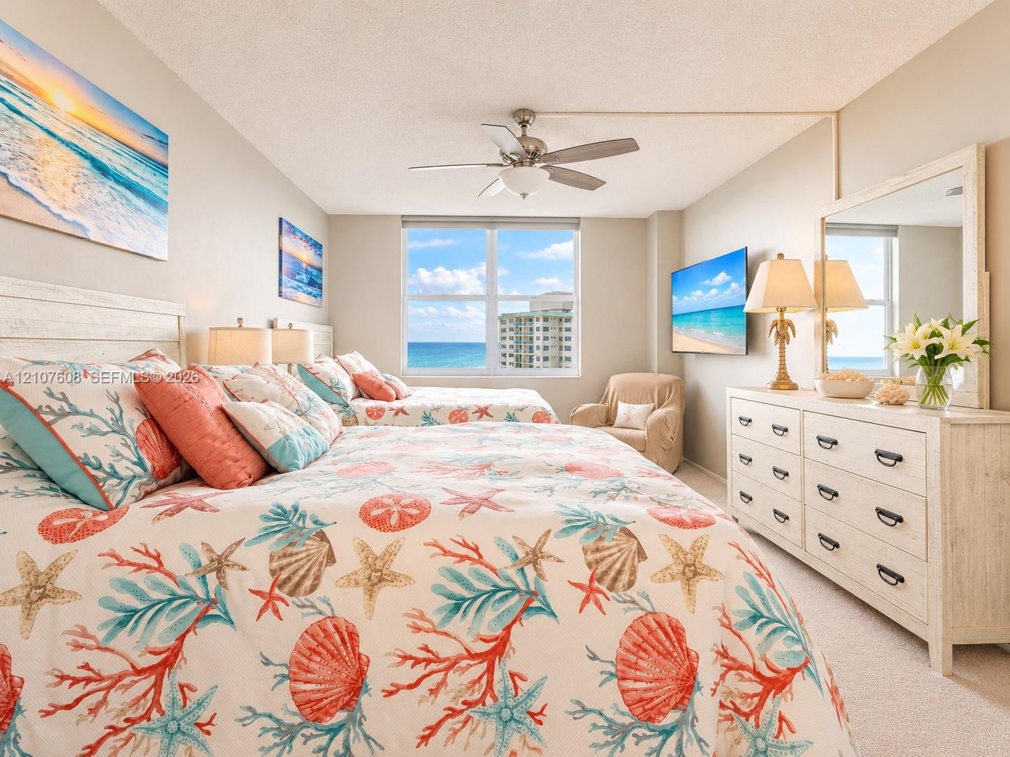 Bedroom featuring a large multi-pane window with water outlook, carpeted flooring, and a ceiling-mounted light fixture with integrated fan