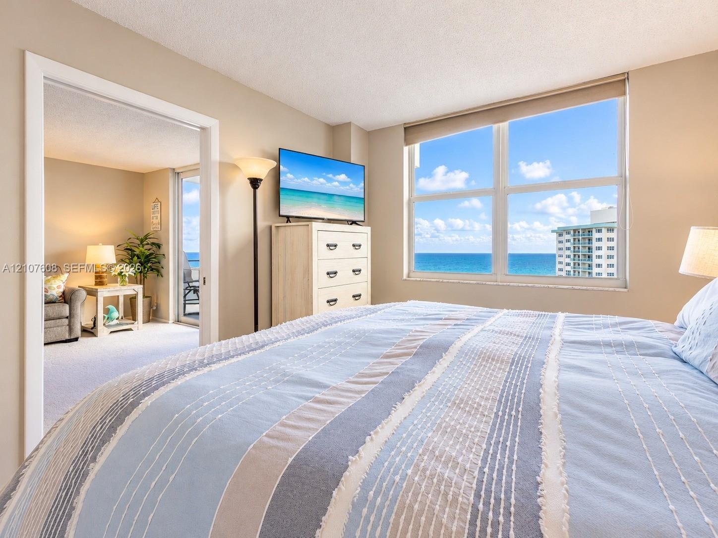 Large windows with ocean horizon and coastal scenery, wall-to-wall carpeting, and sliding glass door