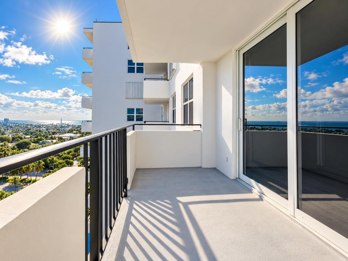Private balcony featuring a concrete surface, black metal railing, and sliding glass door access