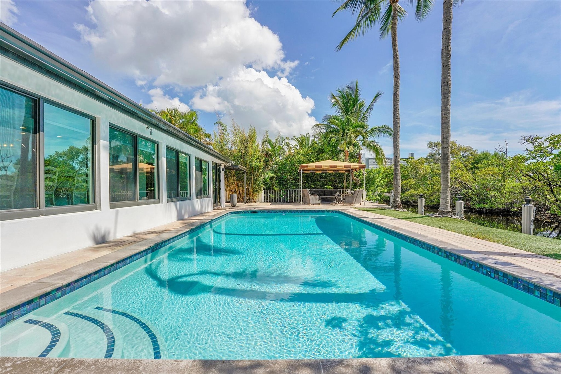 Rectangular pool with tiled steps, surrounded by a paved deck