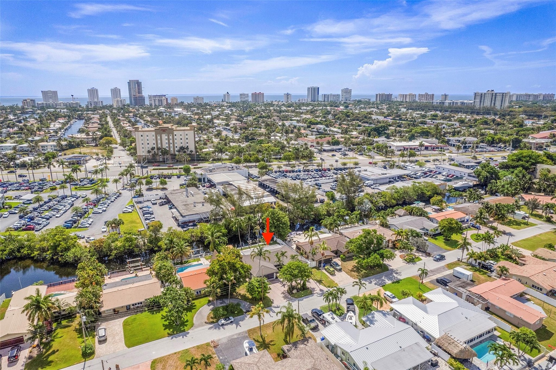 Aerial perspective featuring a canal, residential structures, and commercial properties