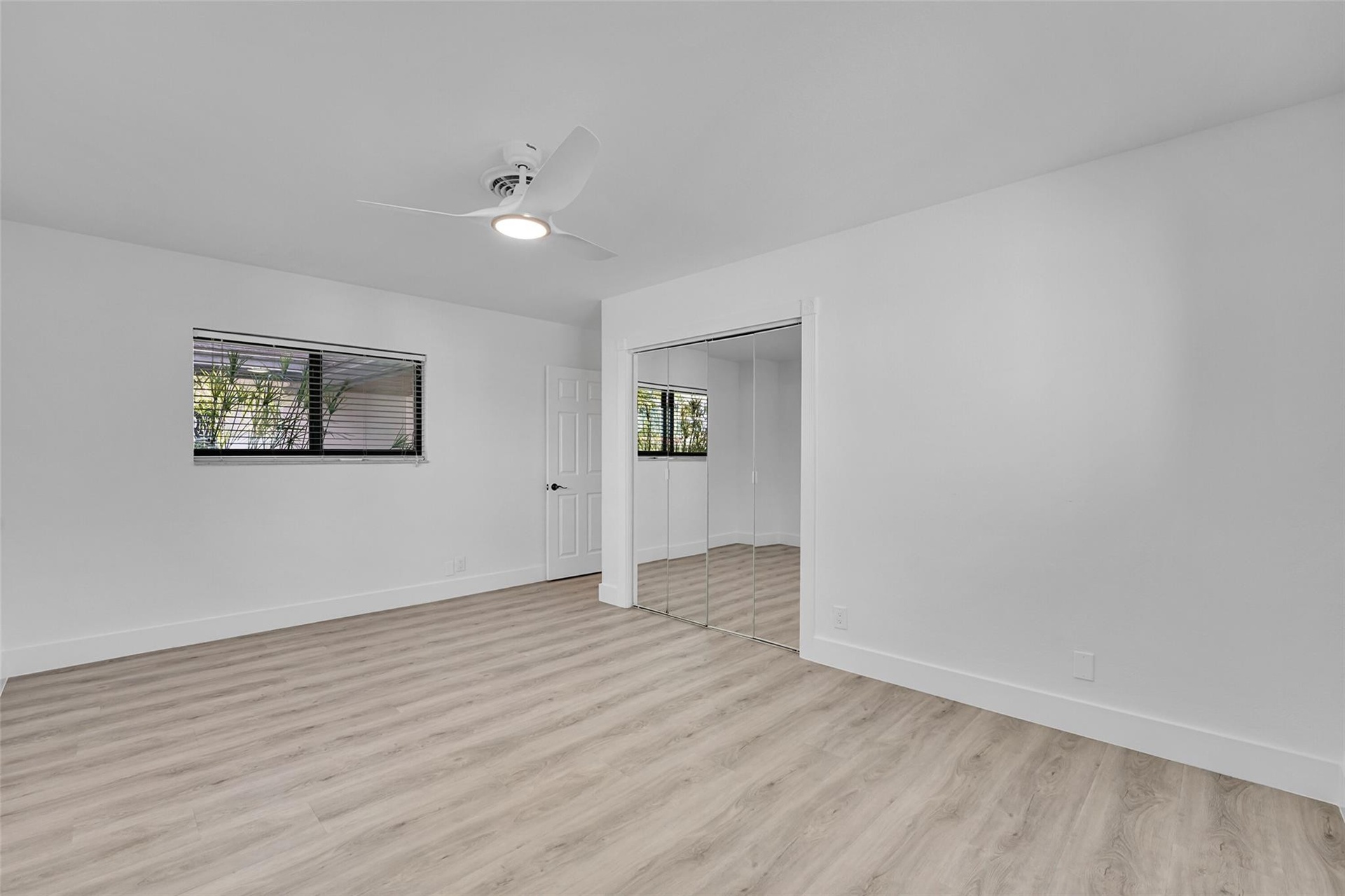 Light wood-finish flooring with white walls