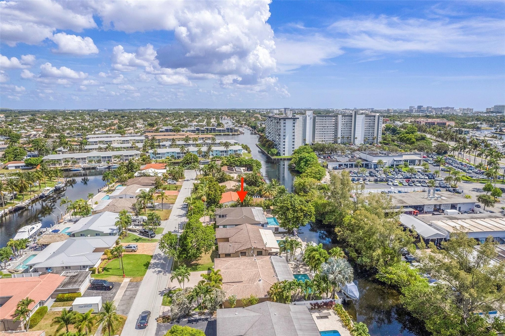 Aerial perspective showcasing a residential property with a tile roof and a private pool, set among mature trees