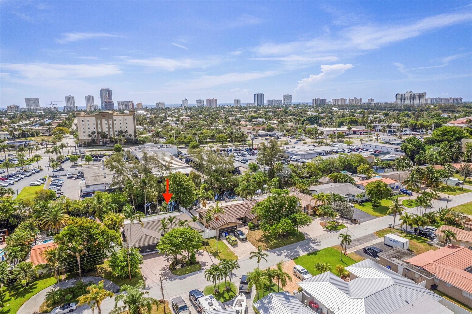 Aerial perspective showcasing a residential property amidst a developed urban area with distant high-rise buildings