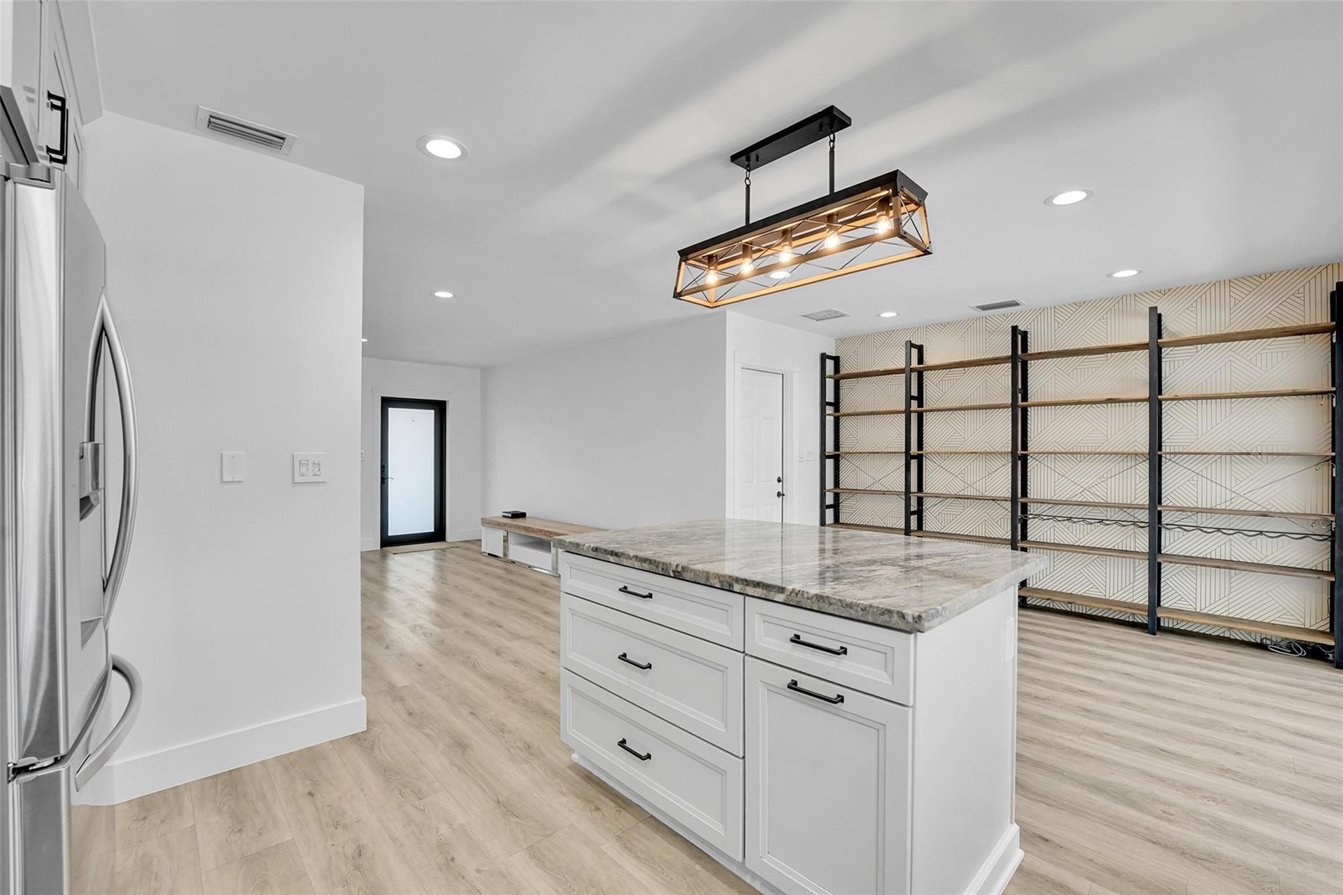 Kitchen island with a light-colored countertop and white cabinetry