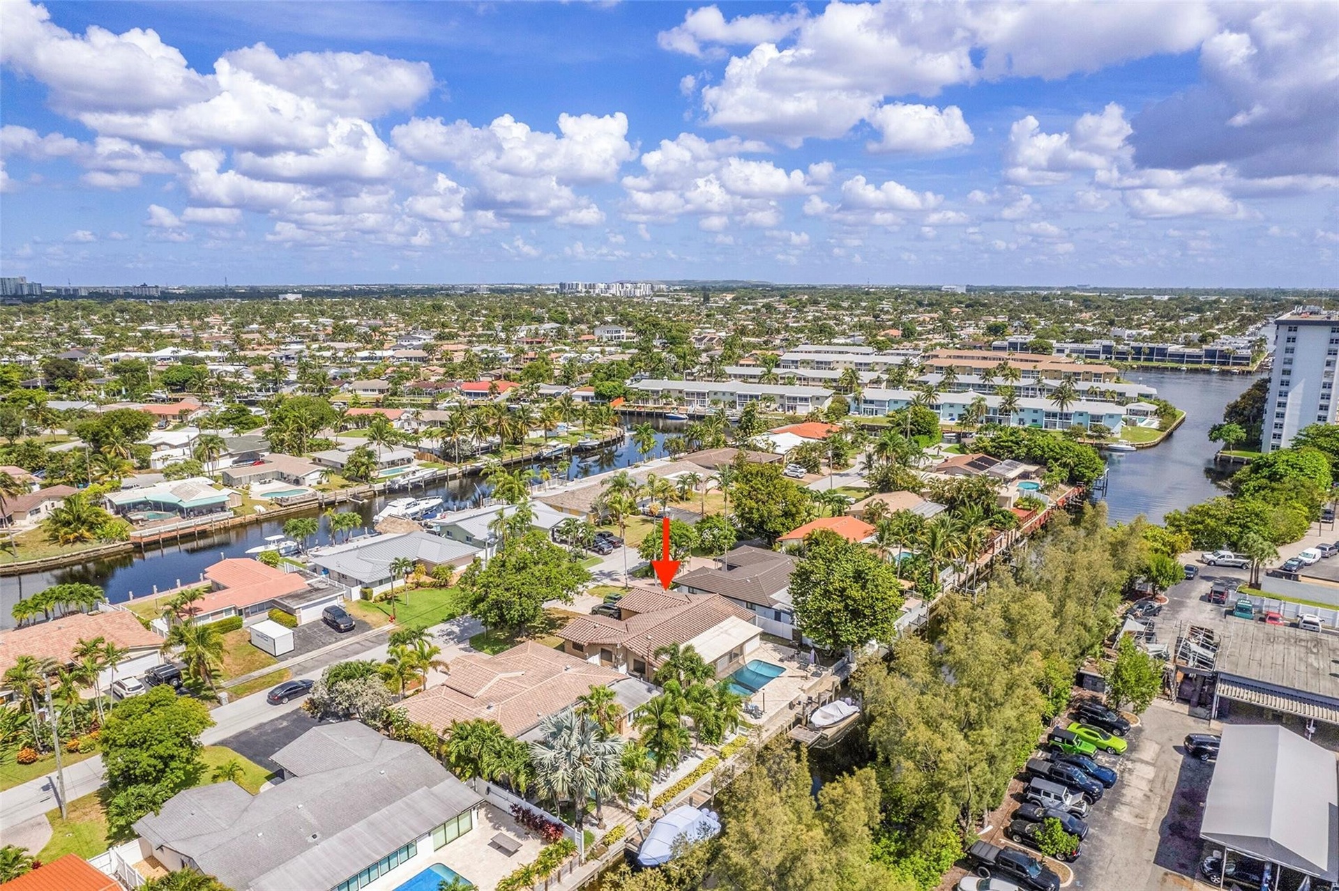 Waterfront property featuring a private boat dock, mature landscaping, and an inground swimming pool