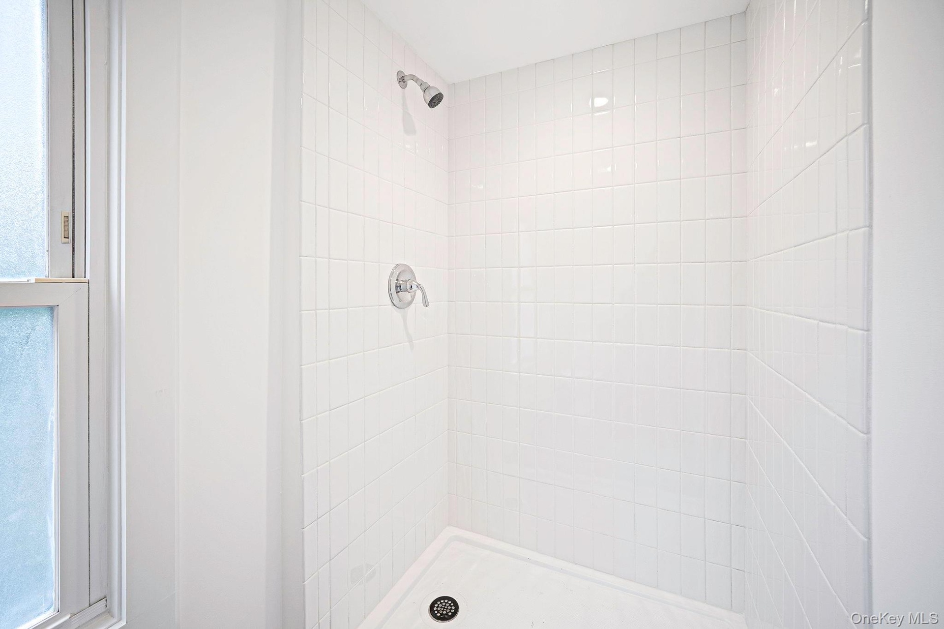 Second floor shower stall featuring white square tile surround, white basin, and polished chrome fixtures