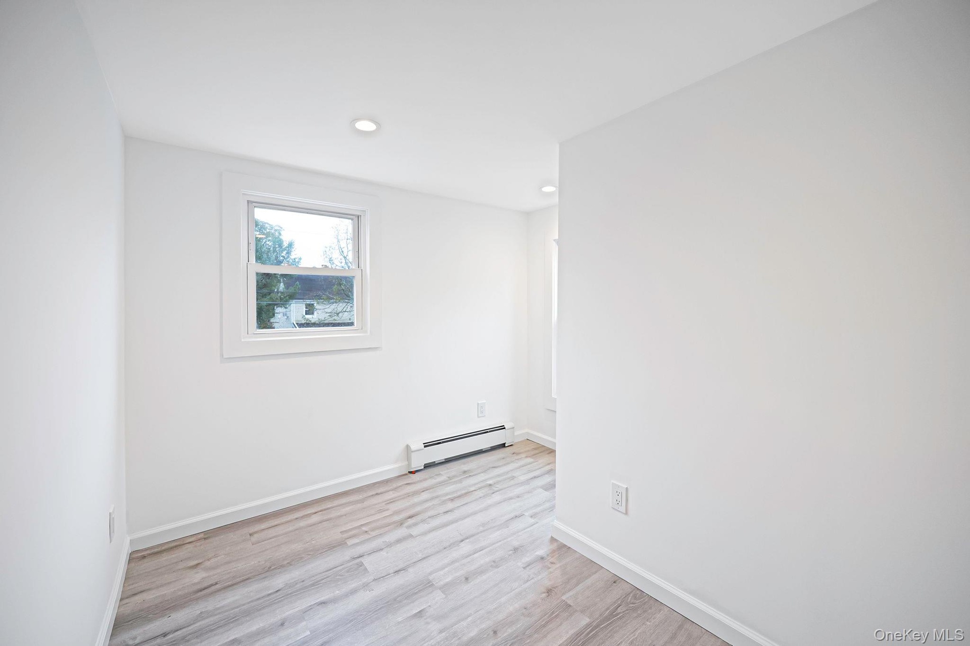 Neutral interior space featuring vinyl wood-finish flooring, recessed lighting, and double-pane windows