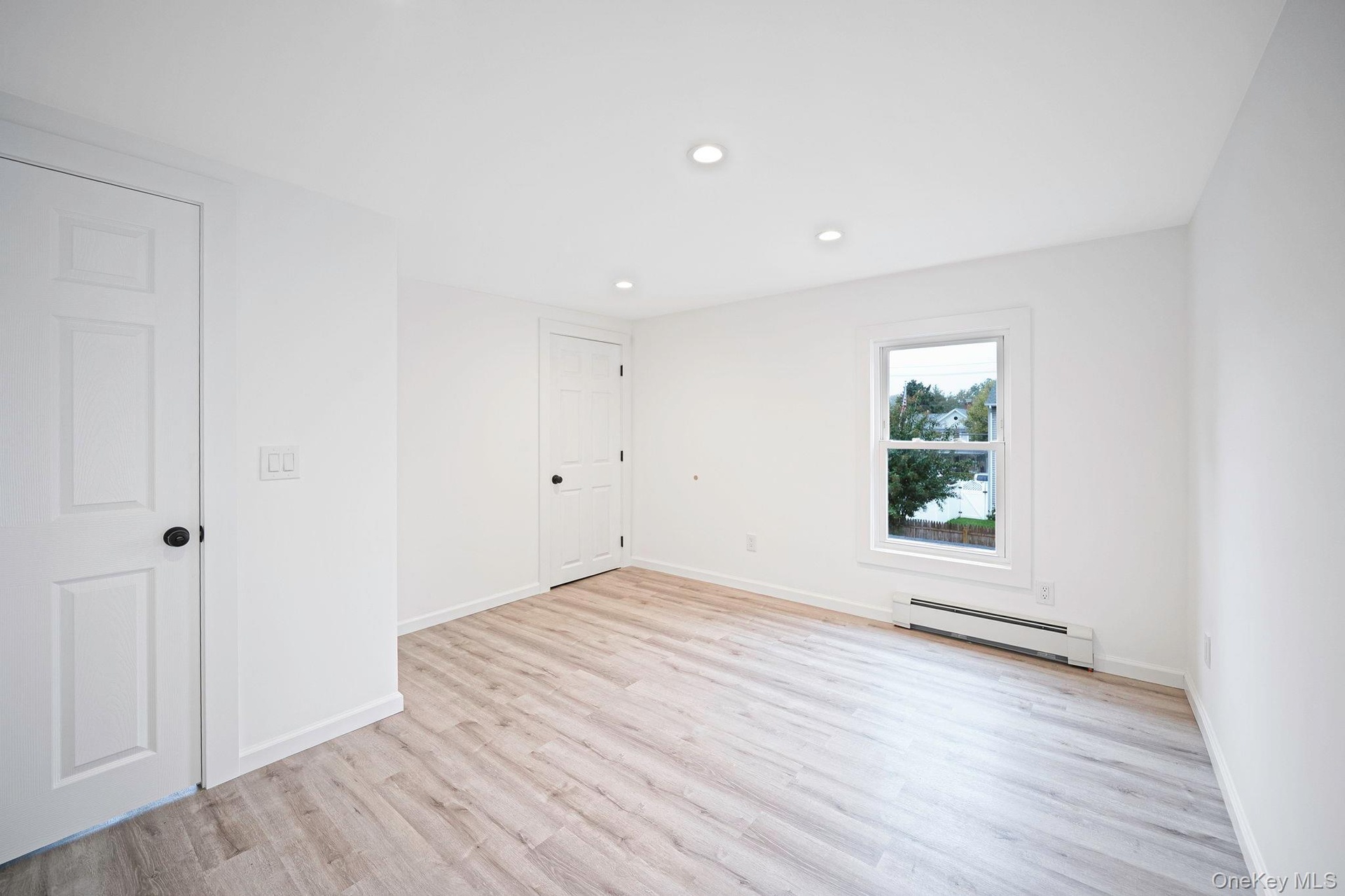 Room featuring vinyl wood-finish flooring, recessed lighting, and white six-panel doors