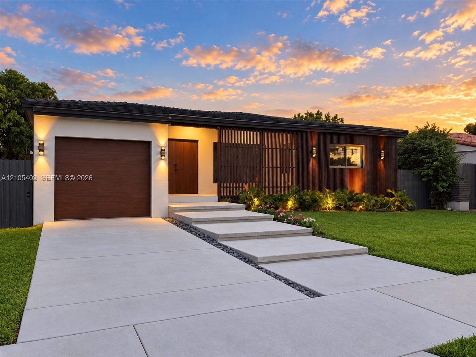 Modern exterior featuring a combination of stucco and wood-finish cladding, single-car garage, integrated screen paneling, and concrete slab walkway w