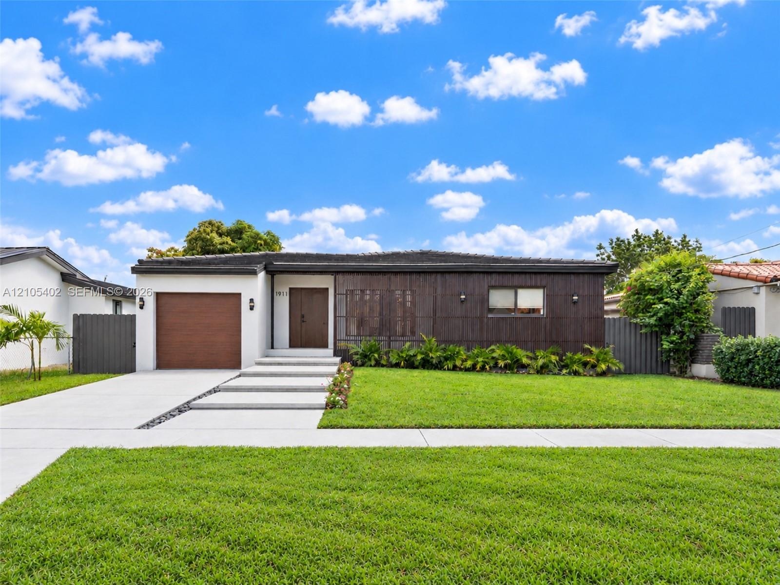 Contemporary single-story exterior featuring dark wood-tone vertical siding, a concrete paver walkway, an integrated single-car garage, and a manicure