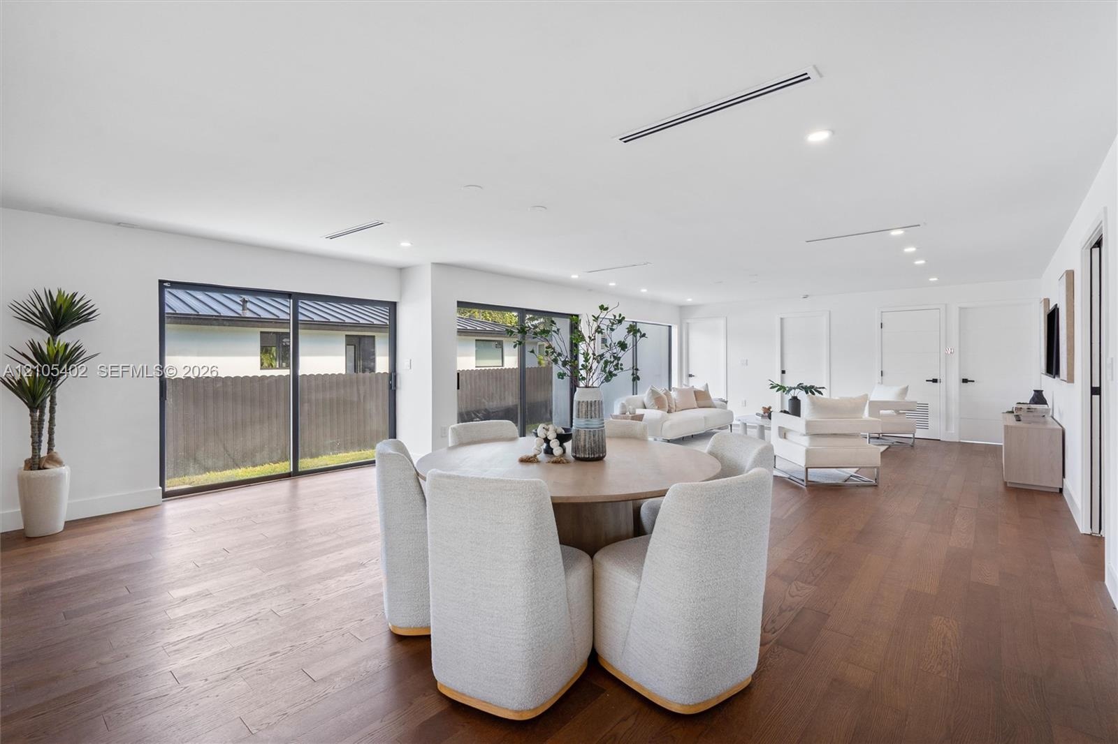 Open-concept interior featuring wood-finish flooring, recessed lighting, and multiple oversized sliding glass doors