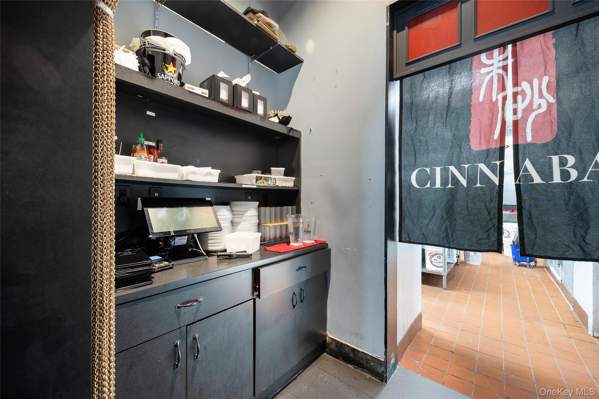 Bar area featuring light tile patterned flooring and gray cabinetry