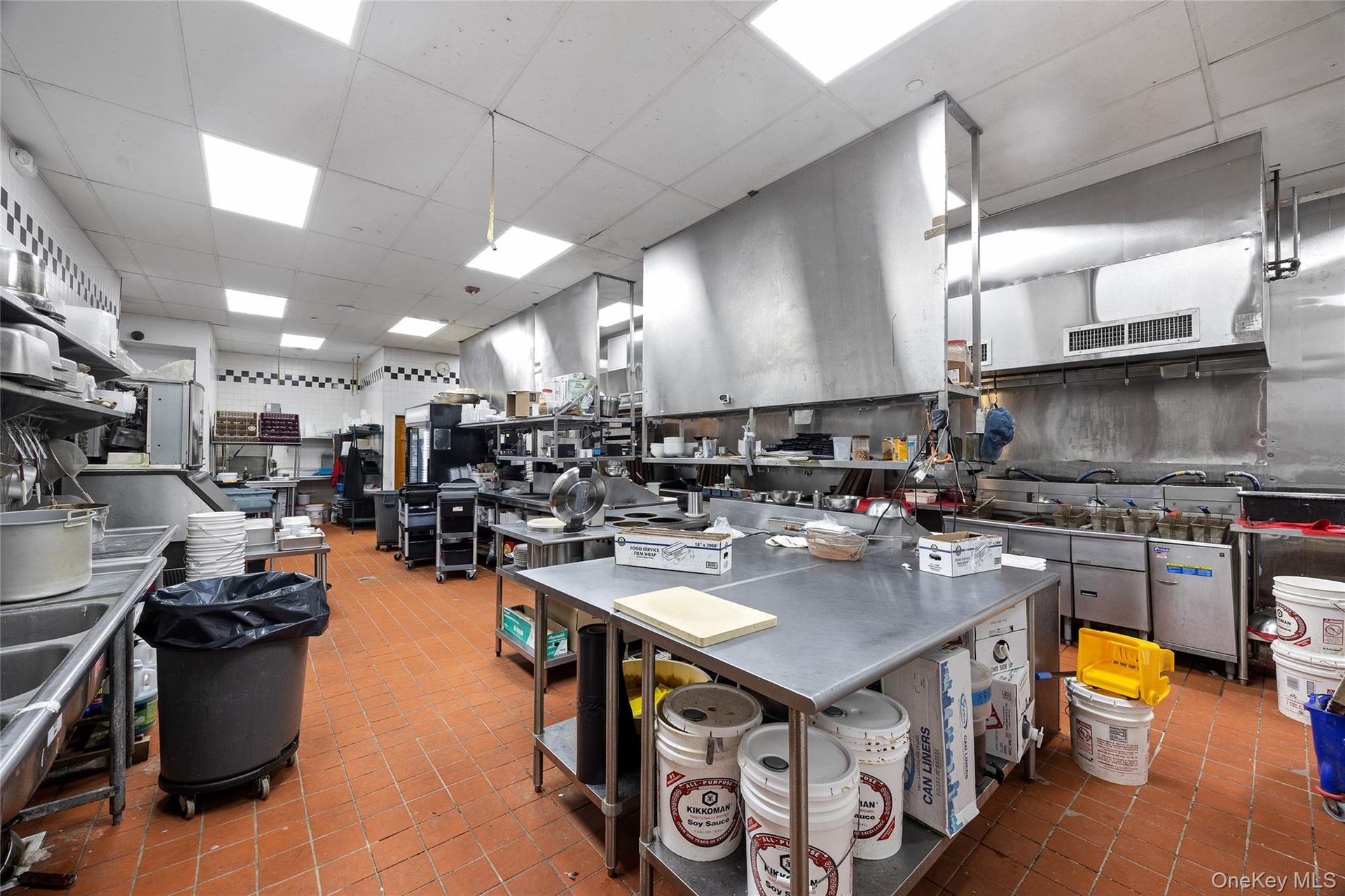 Kitchen featuring a paneled ceiling, stainless steel countertops, and tile patterned floors