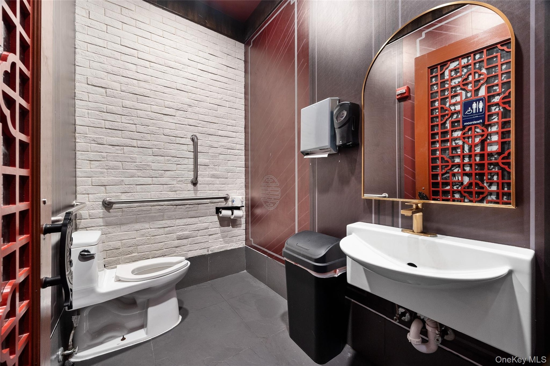Half bathroom featuring toilet and dark tile patterned flooring