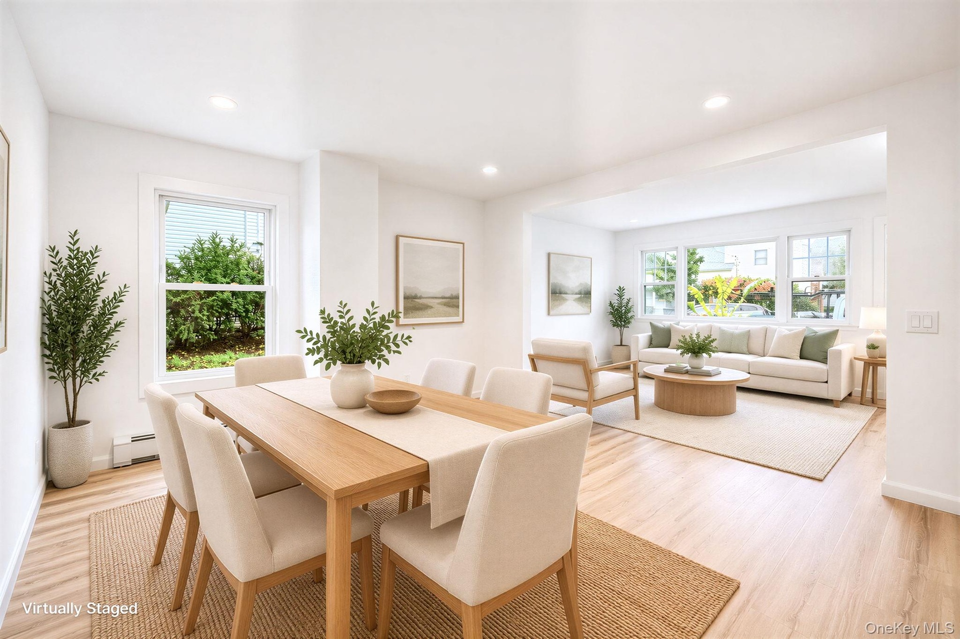 Open-concept living space featuring vinyl wood-finish flooring, recessed lighting, and multiple windows *virtually staged