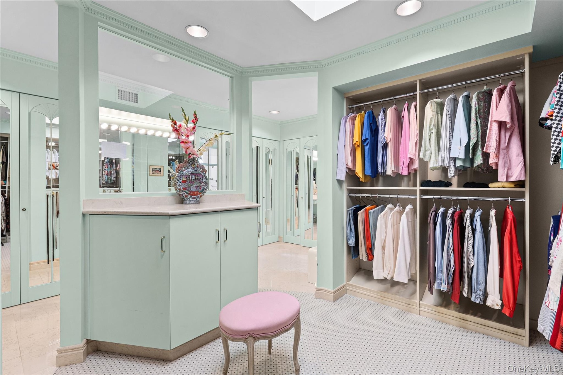 Custom dressing area featuring floor-to-ceiling built-in cabinetry, an integrated vanity with a stone countertop, recessed ceiling lighting, mirrored 