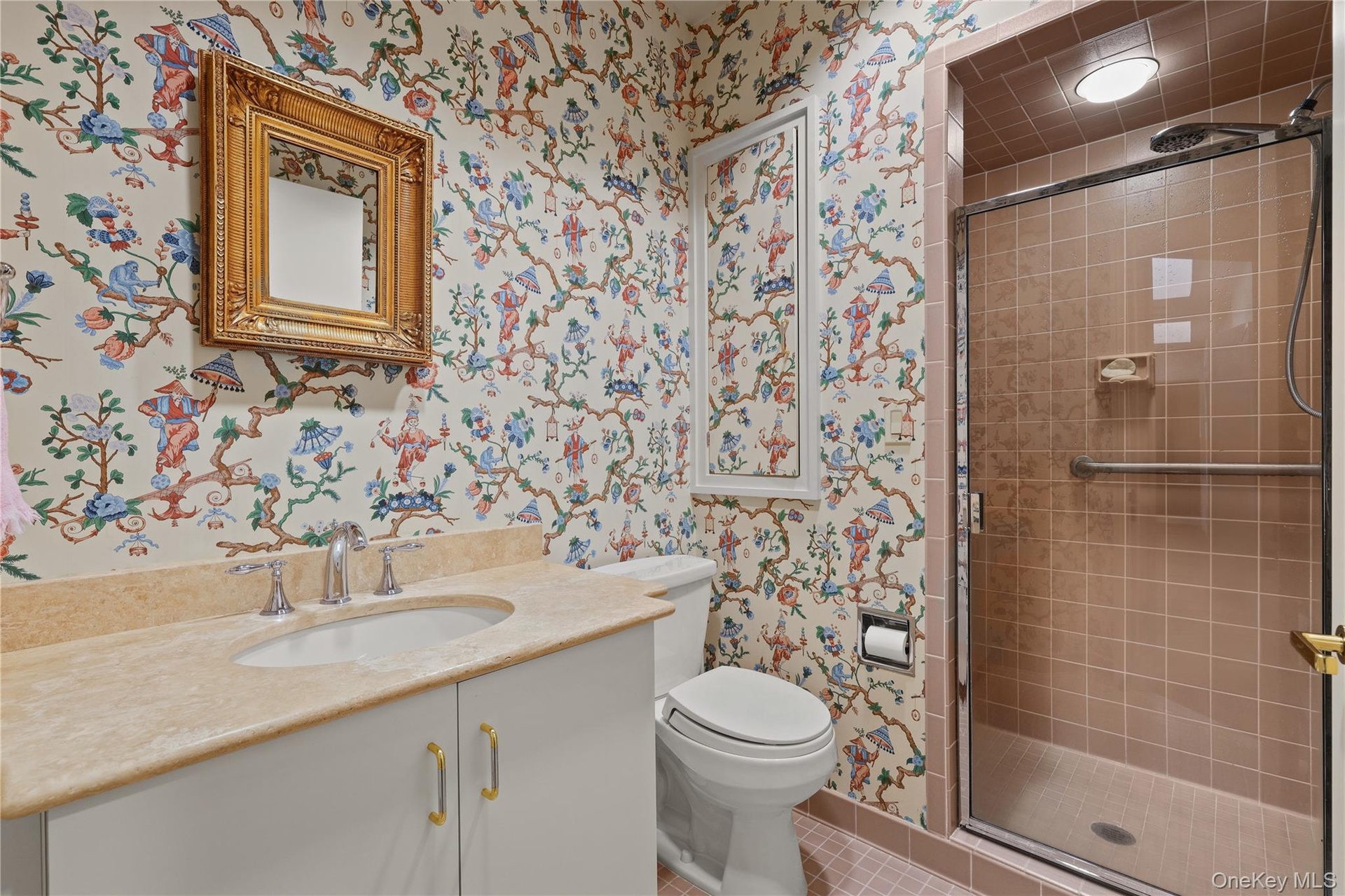 En suite bathroom featuring a solid-surface vanity countertop, undermount sink, built-in cabinetry, walk-in shower with tile surround and glass door, 