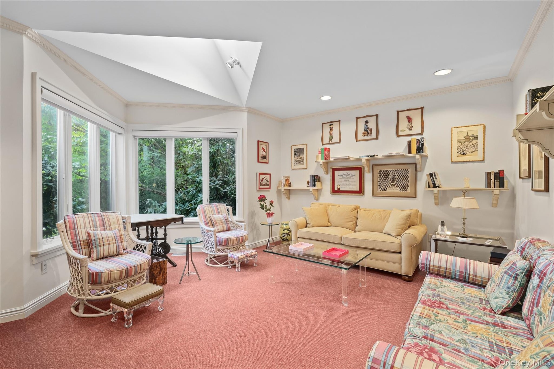 This room doubles as a den and 2nd bedroom. Vaulted ceiling featuring a large skylight, expansive windows, and wall-mounted shelving units