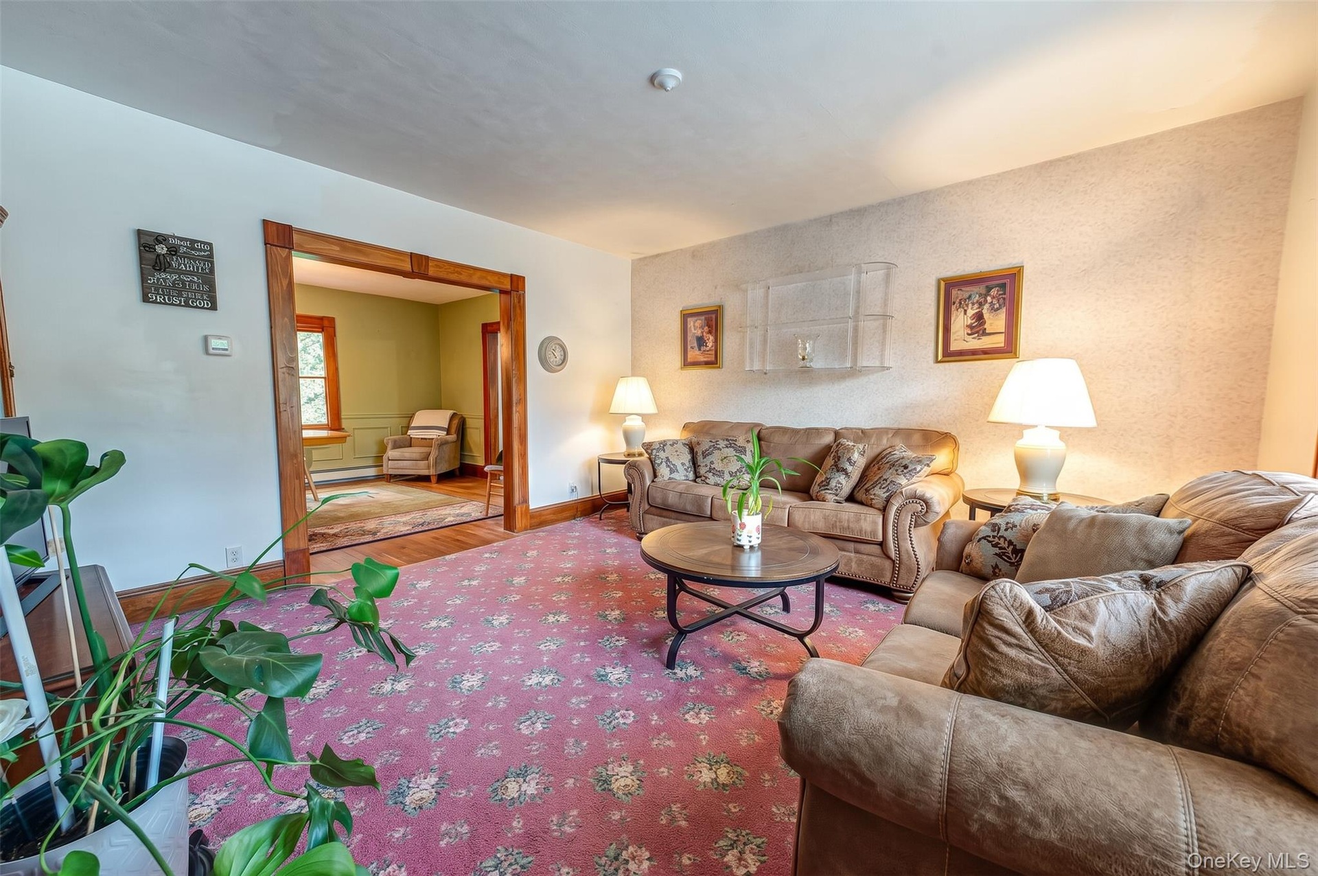 Large living room featuring natural wood molding, hardwood floors.