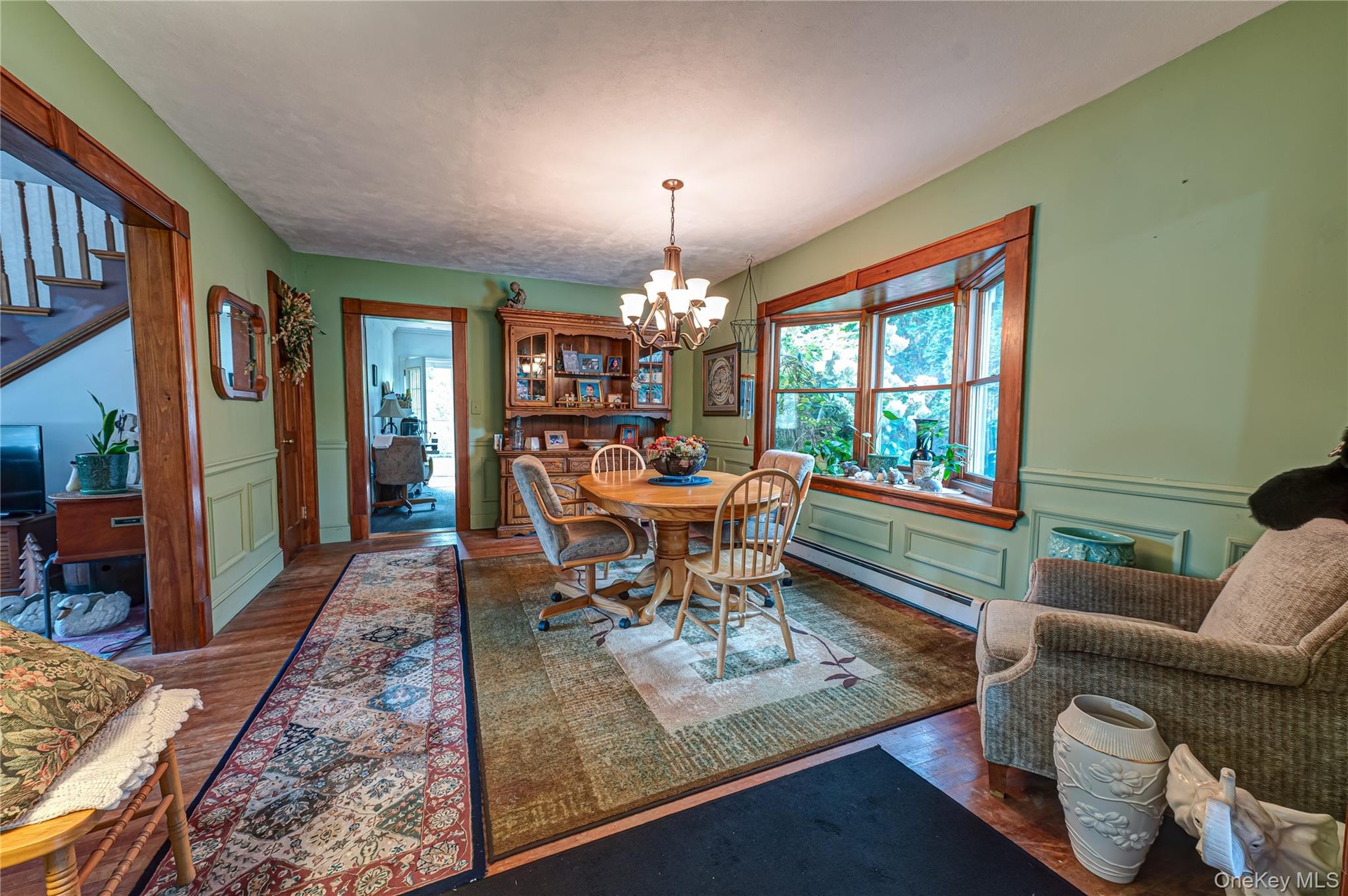Dining space featuring wood-finish flooring, custom moldings, hardwood floors and an expansive bay window.