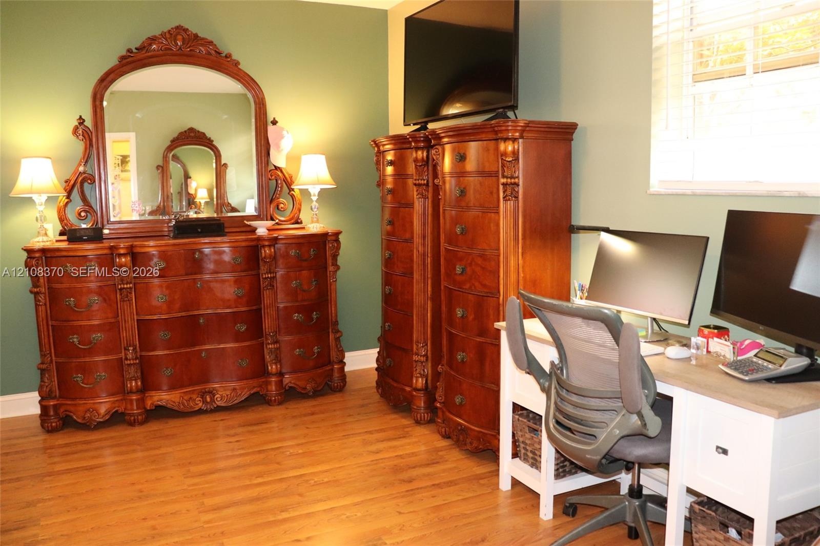 Room featuring wood-finish flooring and a window with horizontal blinds