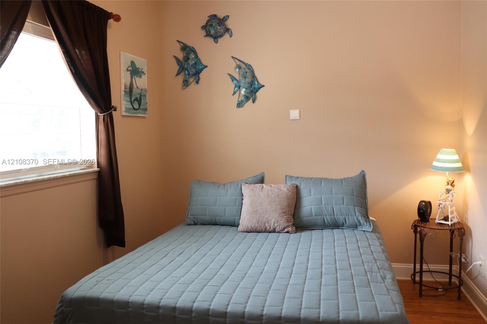 Room featuring neutral-toned walls, hardwood flooring, and a window with a stone sill