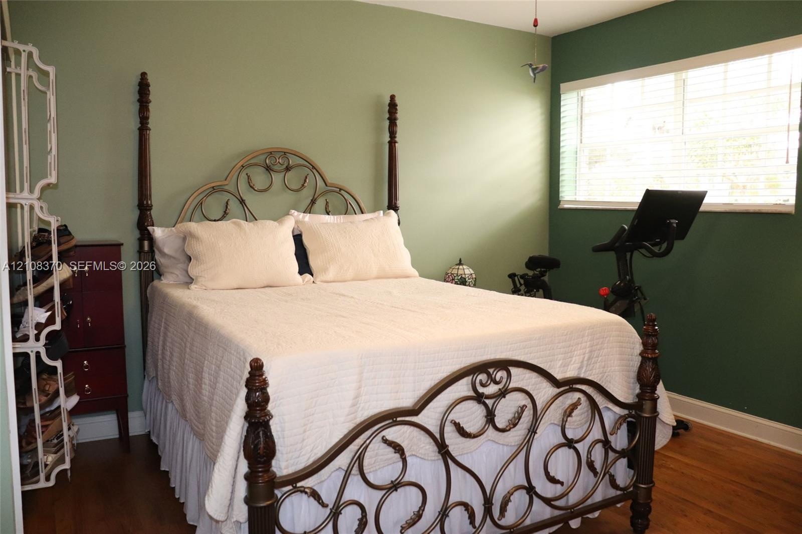 Wood-finish flooring, two-tone painted walls, and a large window featuring horizontal blinds