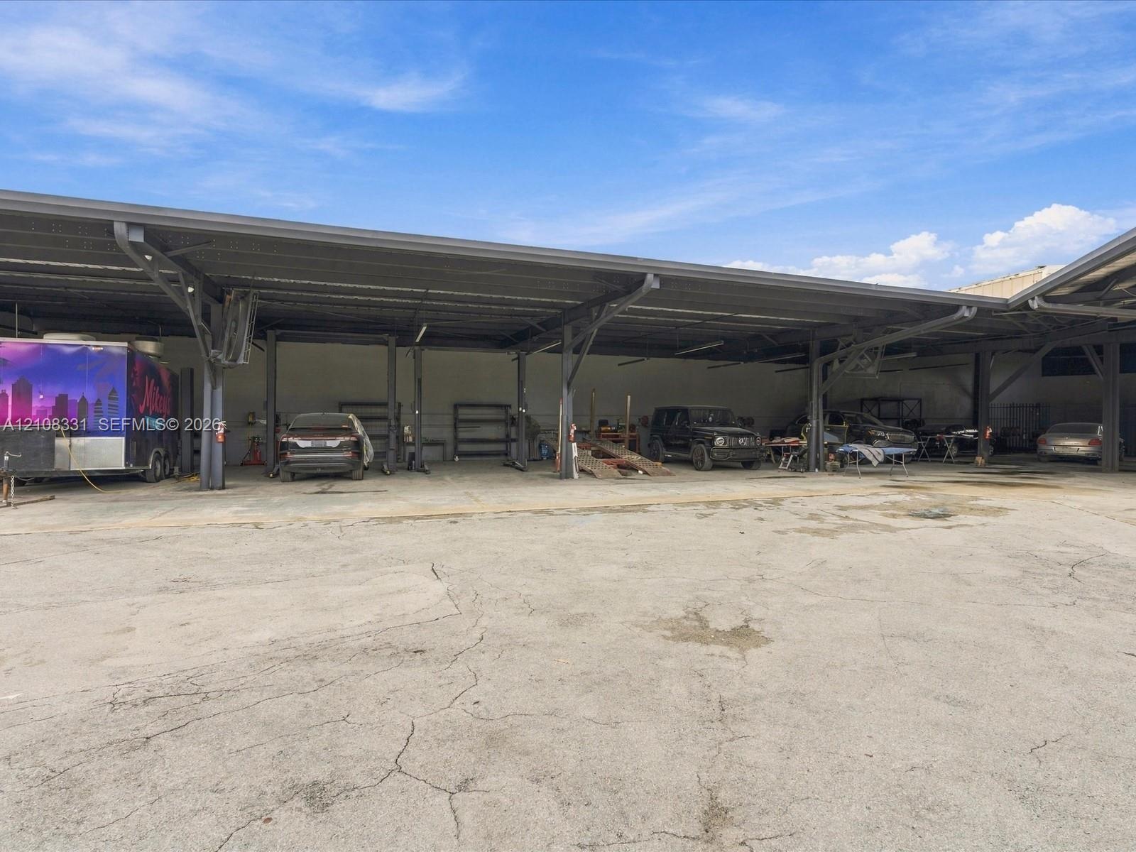 Expansive industrial structure featuring a metal-frame canopy, open-bay workspace, and concrete surface