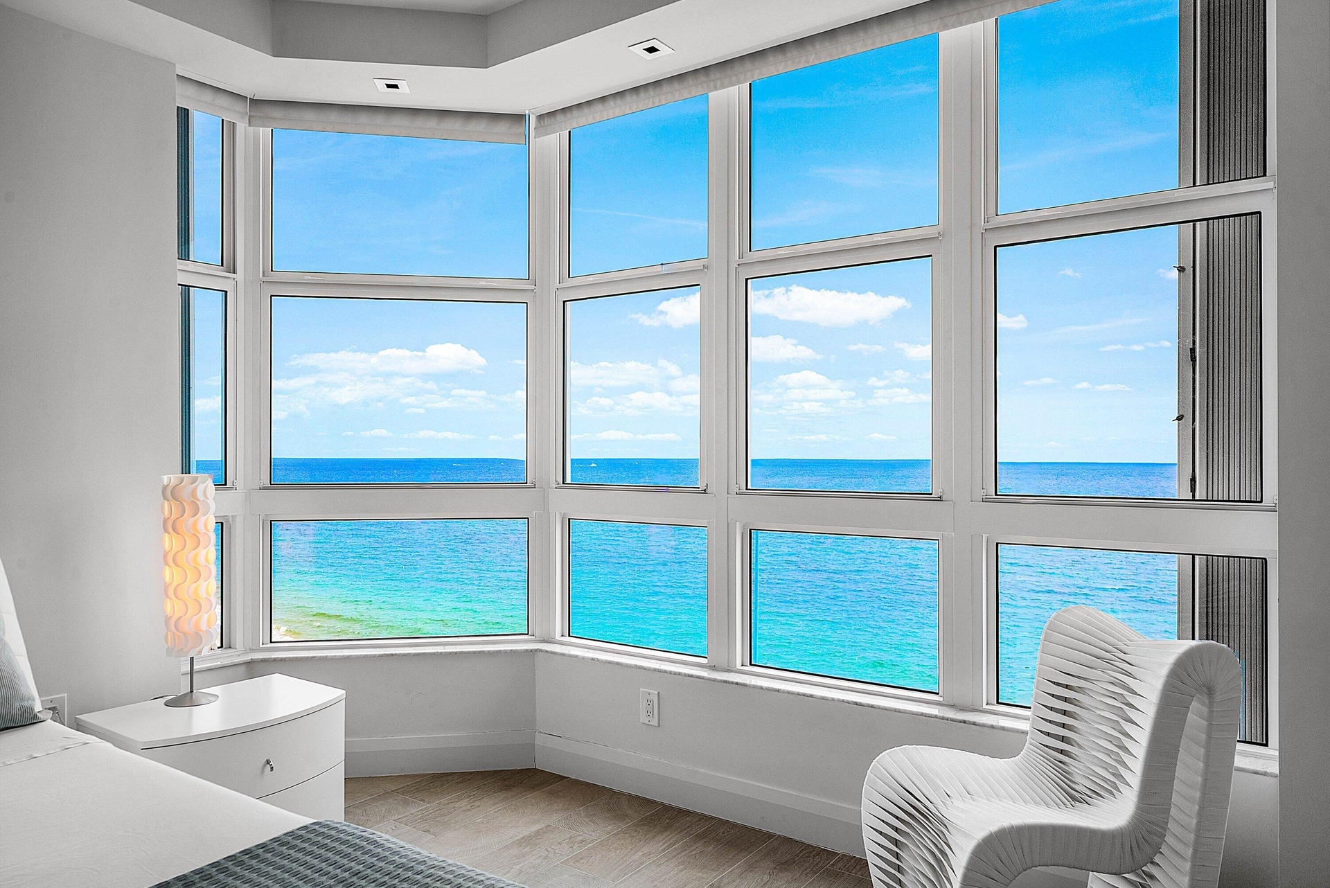Expansive bay window featuring multi-pane glass panels, recessed ceiling lighting, and wood-finish flooring