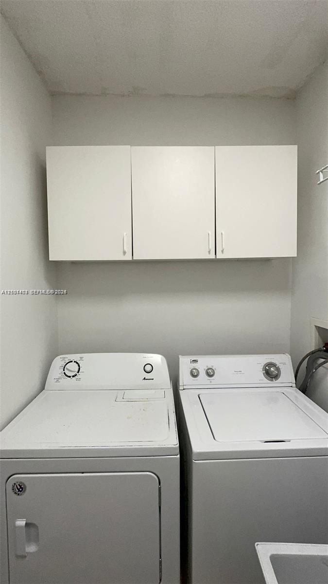 Dedicated laundry area featuring white wall-mounted cabinetry
