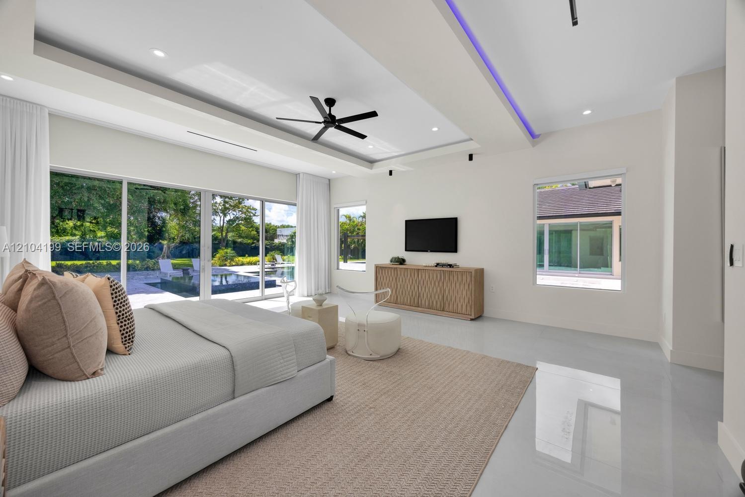 Tray ceiling featuring recessed LED accent lighting, floor-to-ceiling sliding glass doors, polished flooring, a black multi-blade ceiling fan, and rec