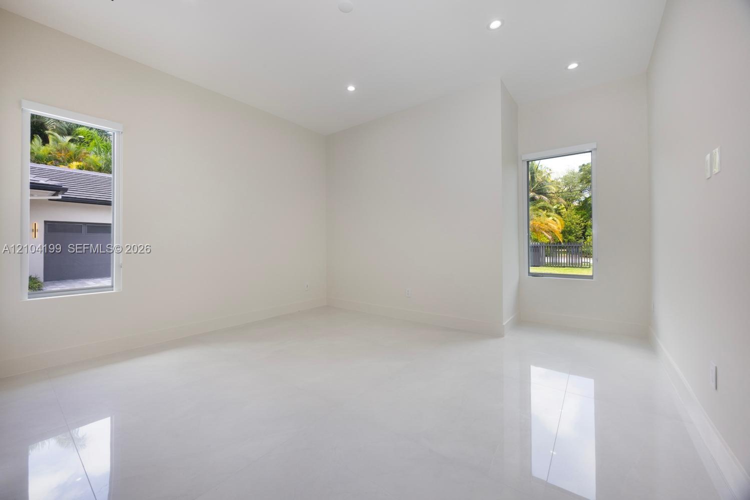 Neutral interior featuring glossy tile flooring, recessed lighting, and dual windows