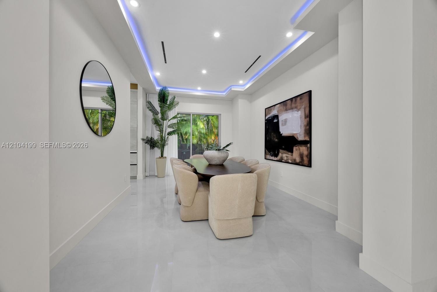 Tray ceiling featuring recessed accent lighting, large-format tile flooring, and sliding glass doors